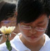 学生手持菊花和纸鹤为大地震遇难者默哀